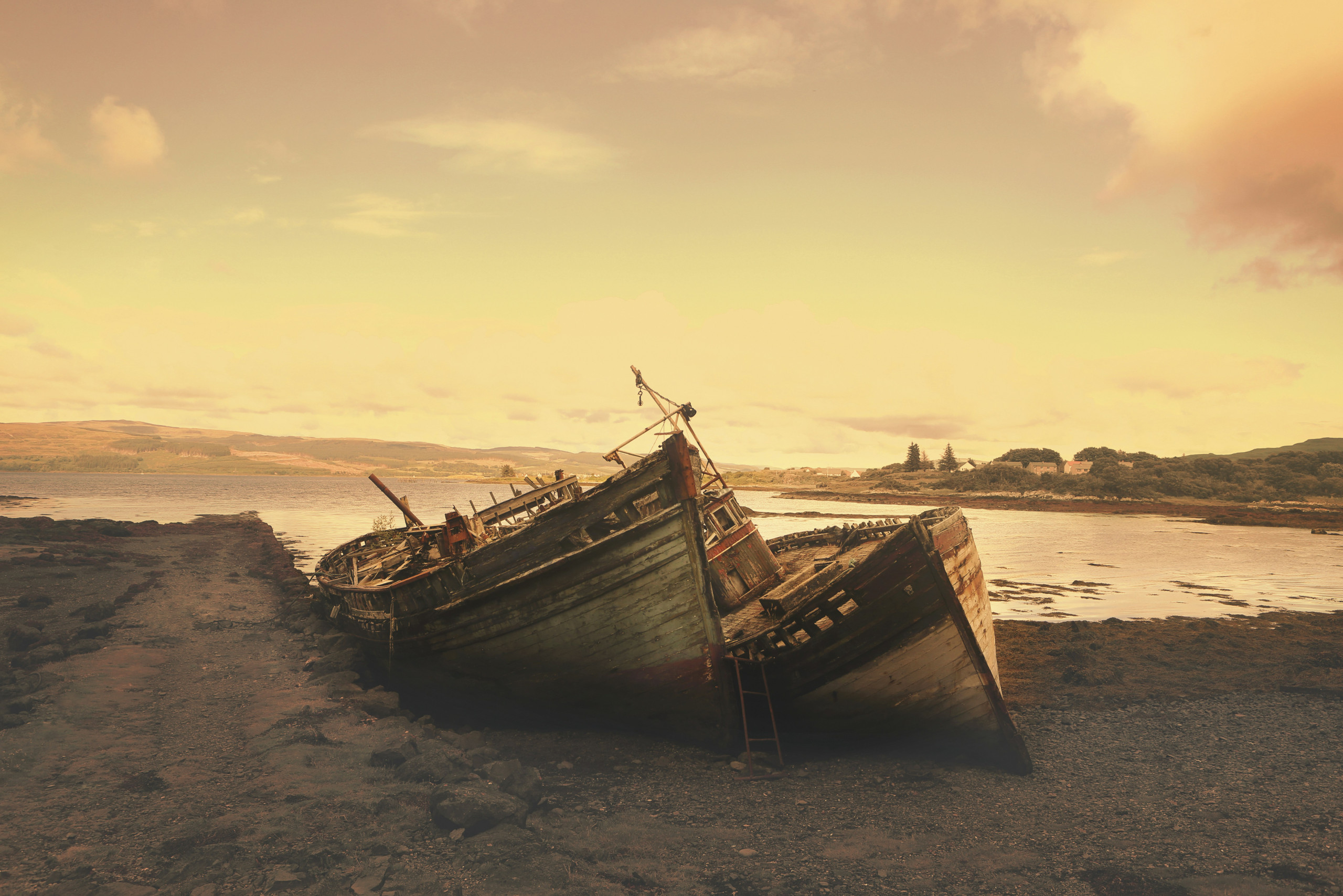 Old boats on a beach at golden hour